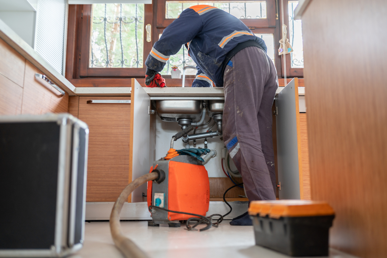Plumber Fixing Clogged Drain